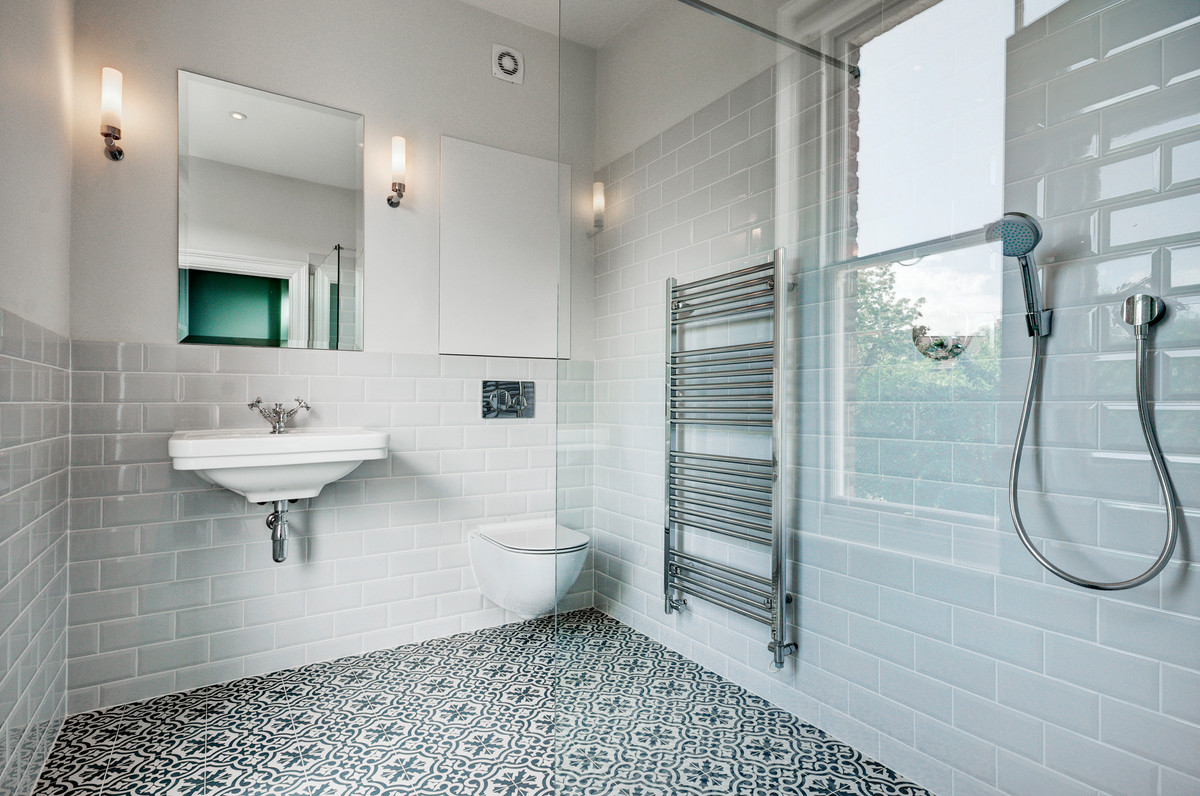 Bild på ett stort funkis en-suite badrum, med släta luckor, en öppen dusch, en vägghängd toalettstol, grå kakel, keramikplattor, cementgolv, ett väggmonterat handfat, flerfärgat golv och med dusch som är öppen