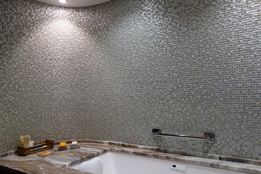Ejemplo de cuarto de baño minimalista con encimera de granito, bañera encastrada sin remate, baldosas y/o azulejos grises y baldosas y/o azulejos en mosaico