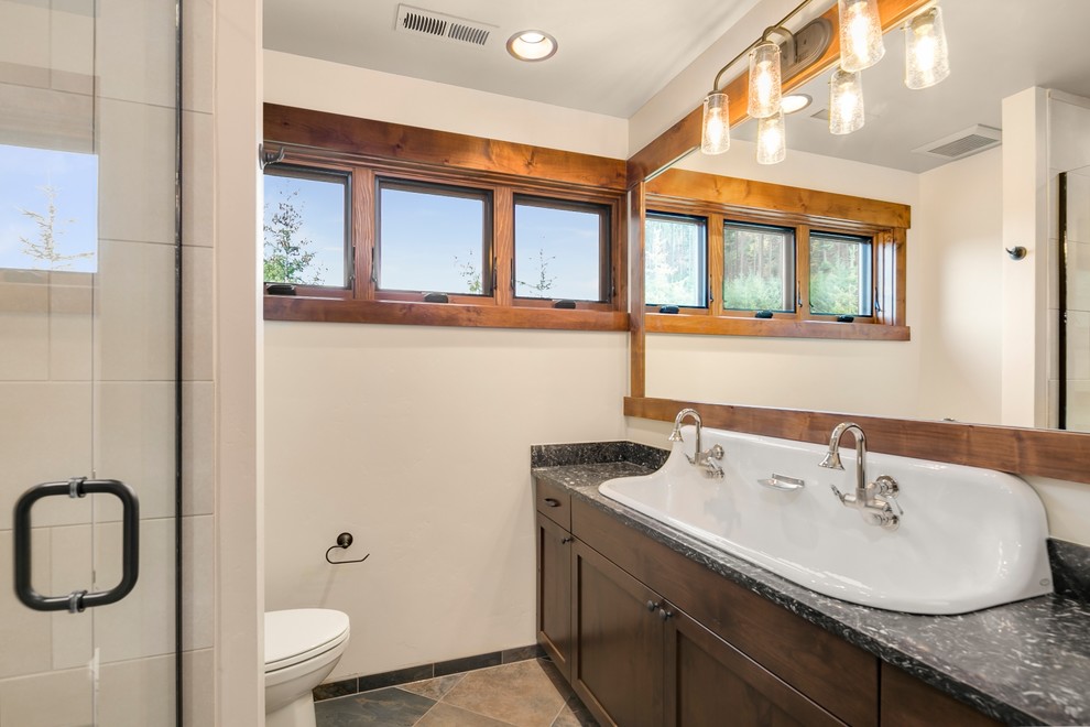 Immagine di una stanza da bagno con doccia rustica con ante con riquadro incassato, ante in legno bruno, WC monopezzo, pistrelle in bianco e nero e pareti bianche