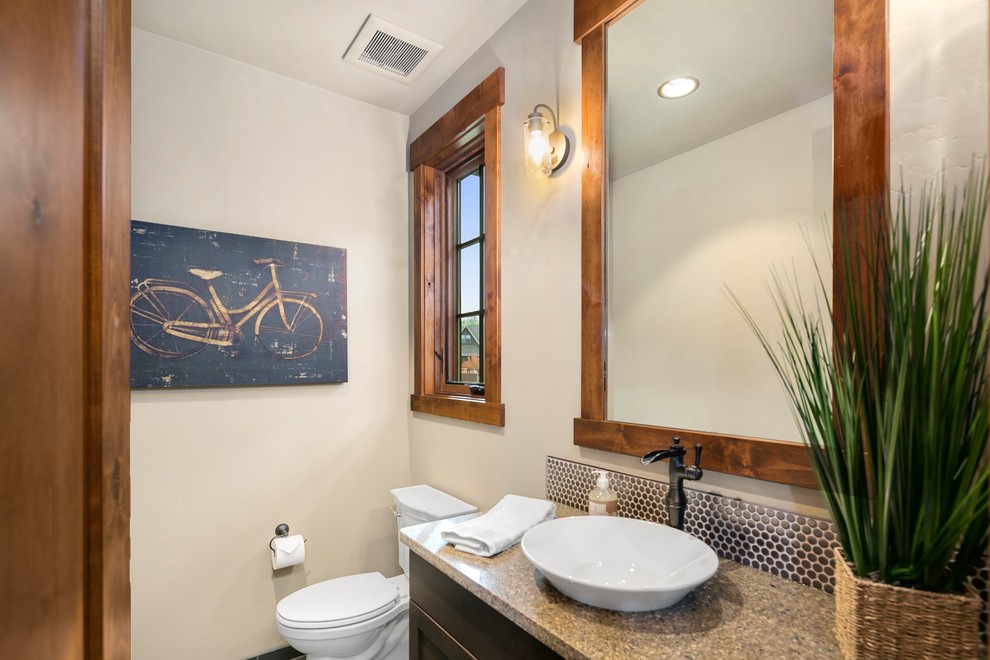 Rustik inredning av ett badrum med dusch, med luckor med infälld panel, skåp i mörkt trä, en toalettstol med hel cisternkåpa, svart kakel och vita väggar