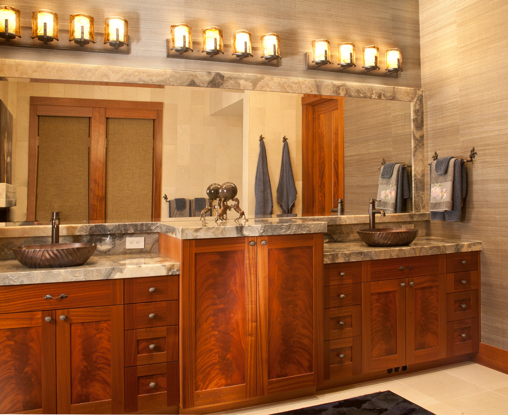 На фото: главная ванная комната в стиле кантри с фасадами в стиле шейкер, фасадами цвета дерева среднего тона, столешницей из оникса, настольной раковиной и полом из травертина