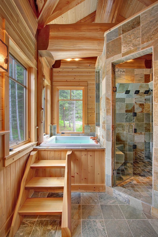 Diseño de cuarto de baño principal rural grande con ducha esquinera, paredes marrones, encimera de madera, bañera encastrada, suelo gris y ducha con puerta con bisagras
