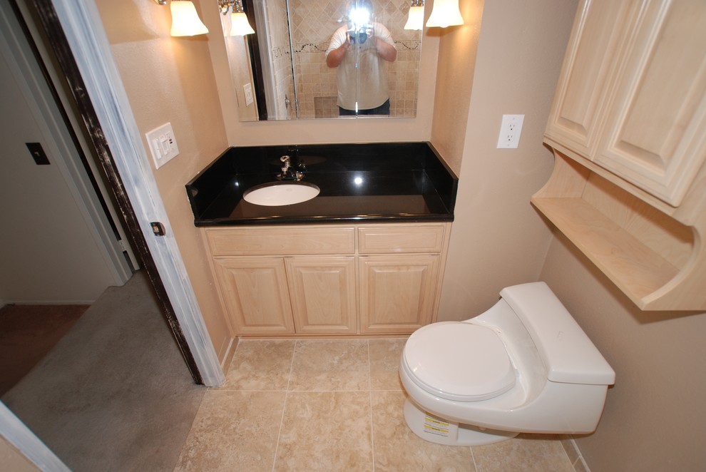 Small tuscan master beige tile and stone tile travertine floor drop-in bathtub photo in Orange County with an undermount sink, raised-panel cabinets, light wood cabinets, granite countertops, a one-piece toilet and beige walls