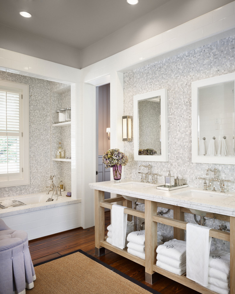 Bild på ett stort lantligt en-suite badrum, med grå kakel, vit kakel, mosaik, mörkt trägolv, ett undermonterad handfat, öppna hyllor, skåp i ljust trä, ett badkar i en alkov, grå väggar och marmorbänkskiva