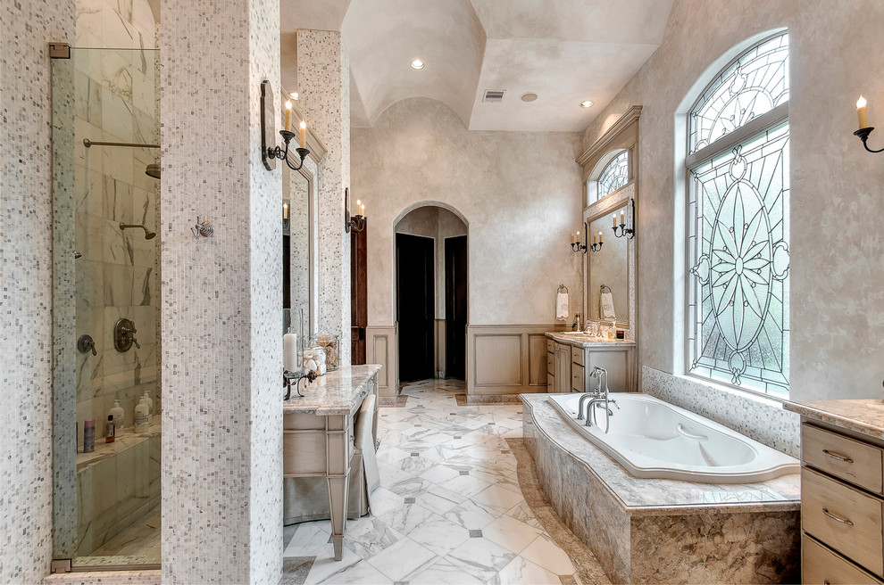 Inspiration for an expansive mediterranean ensuite bathroom in Houston with a submerged sink, freestanding cabinets, distressed cabinets, granite worktops, a built-in bath, a double shower, a two-piece toilet, grey tiles, stone tiles, grey walls and marble flooring.