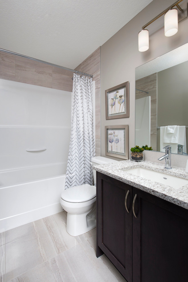 This is an example of a medium sized traditional family bathroom in Calgary with recessed-panel cabinets, medium wood cabinets, an alcove bath, grey tiles, grey walls, ceramic flooring, a pedestal sink and granite worktops.