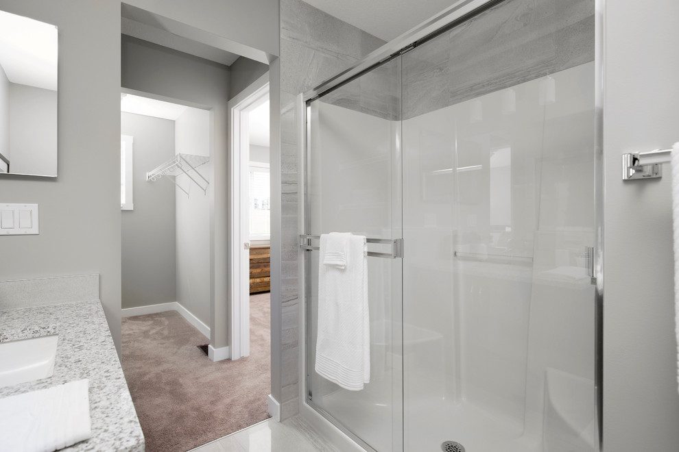 Inspiration for a medium sized classic ensuite bathroom in Calgary with recessed-panel cabinets, medium wood cabinets, an alcove shower, grey tiles, grey walls, ceramic flooring, a pedestal sink and granite worktops.
