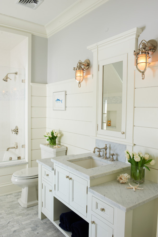 ニューヨークにあるビーチスタイルのおしゃれな浴室 (落し込みパネル扉のキャビネット、白いキャビネット、白い壁、アンダーカウンター洗面器) の写真