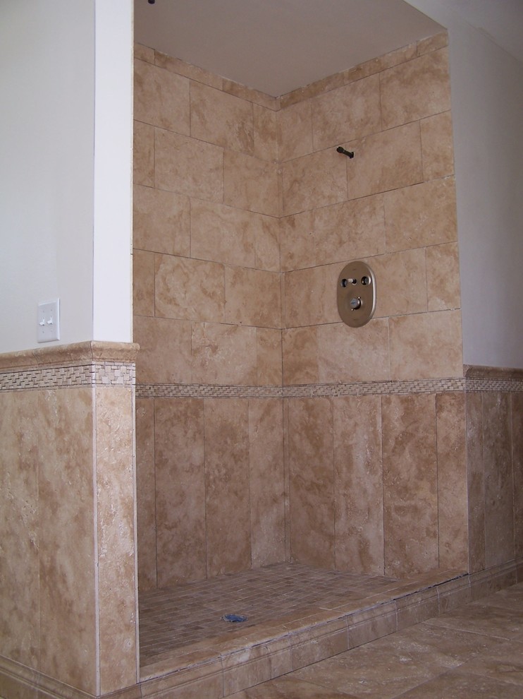 На фото: ванная комната в средиземноморском стиле с открытым душем и каменной плиткой