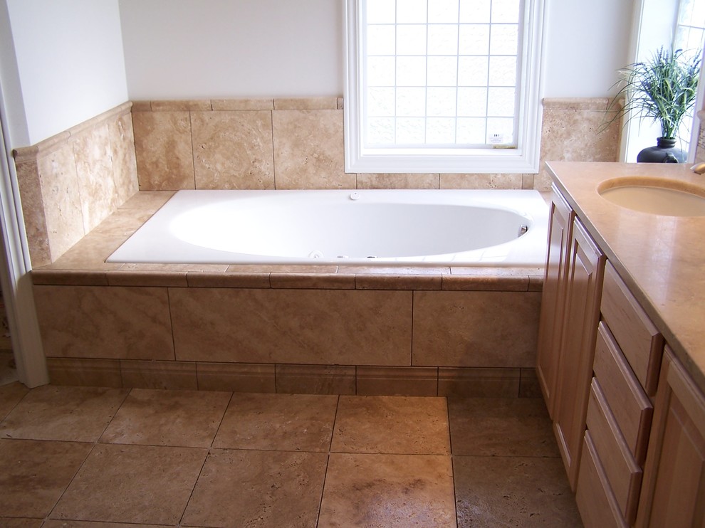 Medelhavsstil inredning av ett badrum, med ett badkar i en alkov, en öppen dusch, beige kakel och stenkakel