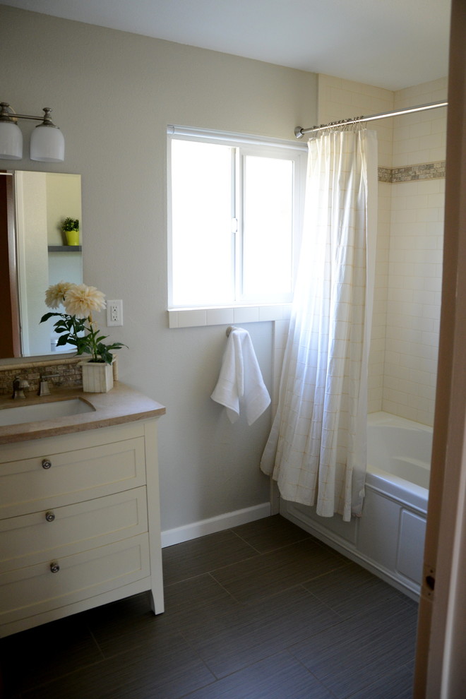 Inspiration för ett mellanstort funkis badrum, med möbel-liknande, vita skåp, ett badkar i en alkov, en dusch i en alkov, en toalettstol med hel cisternkåpa, vit kakel, beige väggar, mellanmörkt trägolv, ett undermonterad handfat, brunt golv och dusch med duschdraperi