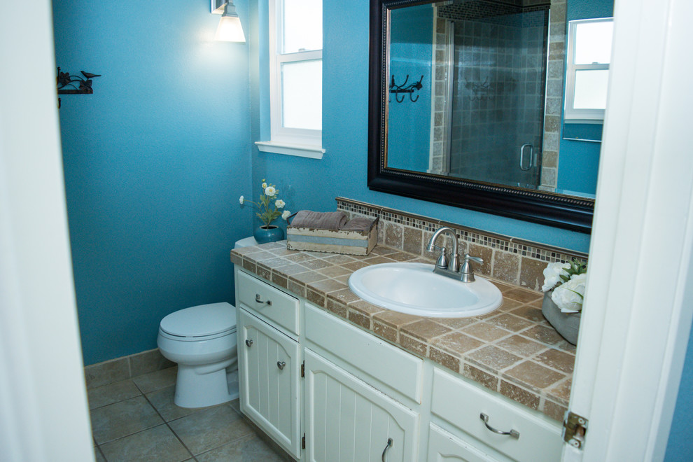 Idéer för mellanstora vintage badrum med dusch, med luckor med lamellpanel, vita skåp, en dusch i en alkov, en toalettstol med hel cisternkåpa, brun kakel, blå väggar, ett nedsänkt handfat, beiget golv och dusch med gångjärnsdörr