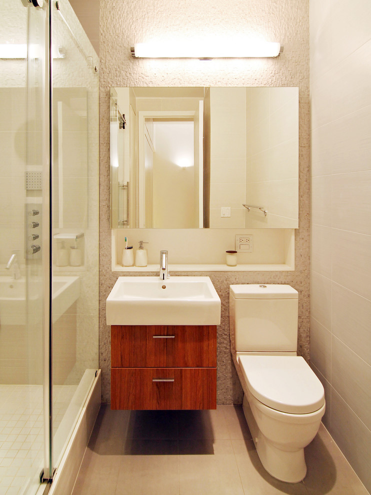 Example of a small minimalist 3/4 beige tile, white tile and ceramic tile ceramic tile and beige floor bathroom design in New York with an integrated sink, medium tone wood cabinets, a two-piece toilet, flat-panel cabinets, beige walls and solid surface countertops