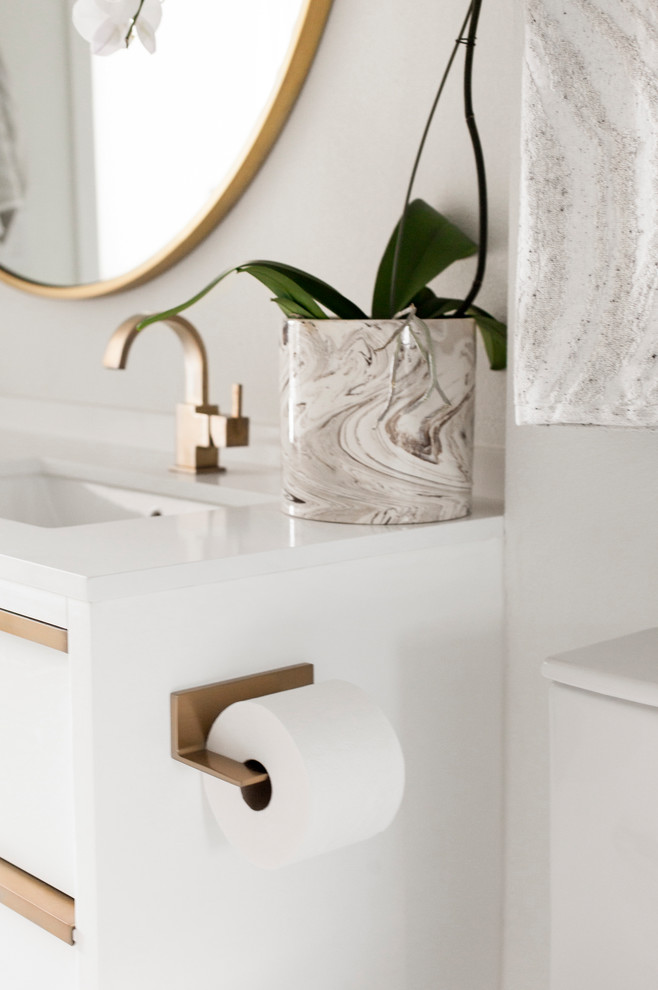 Пример оригинального дизайна: главная ванная комната среднего размера в стиле модернизм с плоскими фасадами, белыми фасадами, ванной в нише, душем над ванной, унитазом-моноблоком, белой плиткой, мраморной плиткой, белыми стенами, мраморным полом, врезной раковиной, столешницей из искусственного кварца, белым полом, душем с распашными дверями и белой столешницей