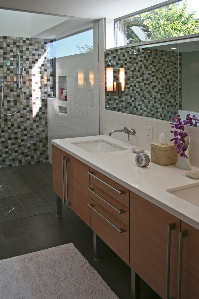 This is an example of a medium sized contemporary ensuite bathroom in Orange County with a submerged sink, medium wood cabinets, a built-in shower, multi-coloured tiles, mosaic tiles, engineered stone worktops, white walls, porcelain flooring and flat-panel cabinets.