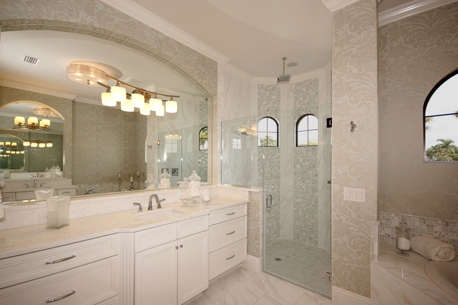 Großes Klassisches Badezimmer En Suite mit Schrankfronten mit vertiefter Füllung, weißen Schränken, Einbaubadewanne, Eckdusche, beiger Wandfarbe, Unterbauwaschbecken, weißem Boden und Falttür-Duschabtrennung in Miami