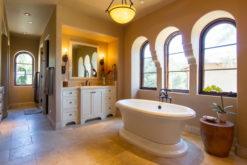 Inspiration för stora klassiska badrum med dusch, med skåp i shakerstil, vita skåp, ett fristående badkar, beige väggar, kalkstensgolv, ett undermonterad handfat och beiget golv
