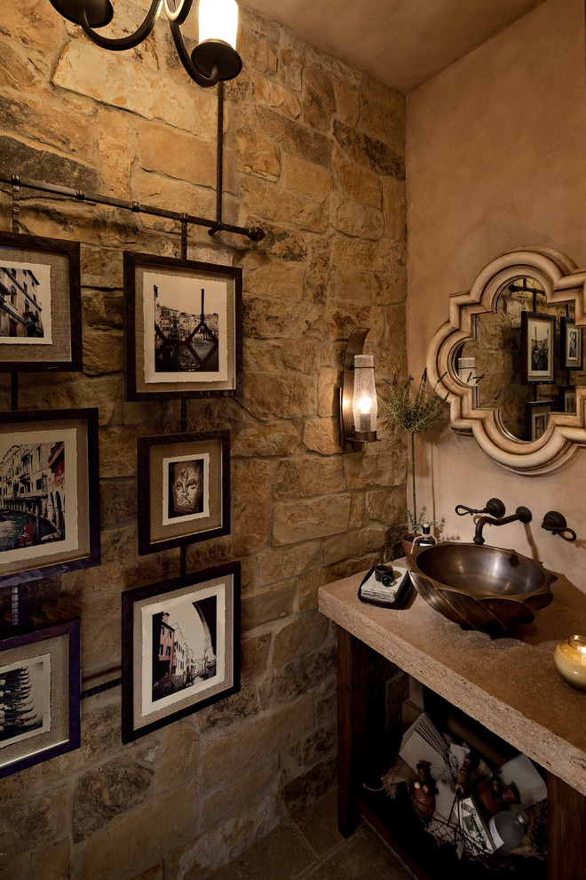 Cette image montre une salle d'eau méditerranéenne en bois vieilli de taille moyenne avec un placard en trompe-l'oeil, WC séparés, un carrelage marron, un carrelage de pierre, un mur beige, un sol en travertin, une vasque et un plan de toilette en surface solide.