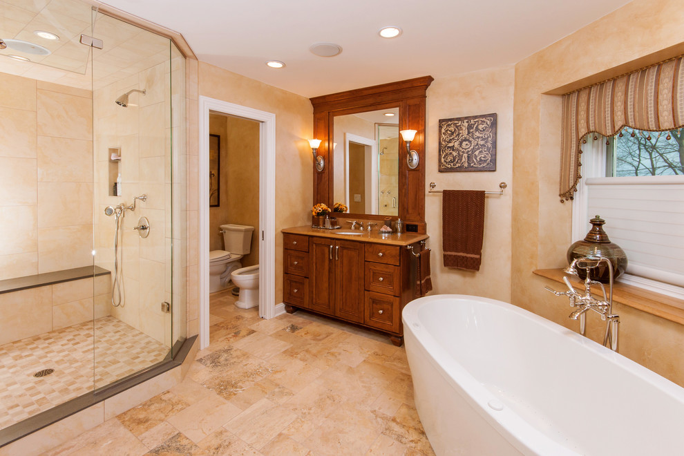 Imagen de cuarto de baño tradicional con bañera exenta, baldosas y/o azulejos de piedra y cuarto de baño