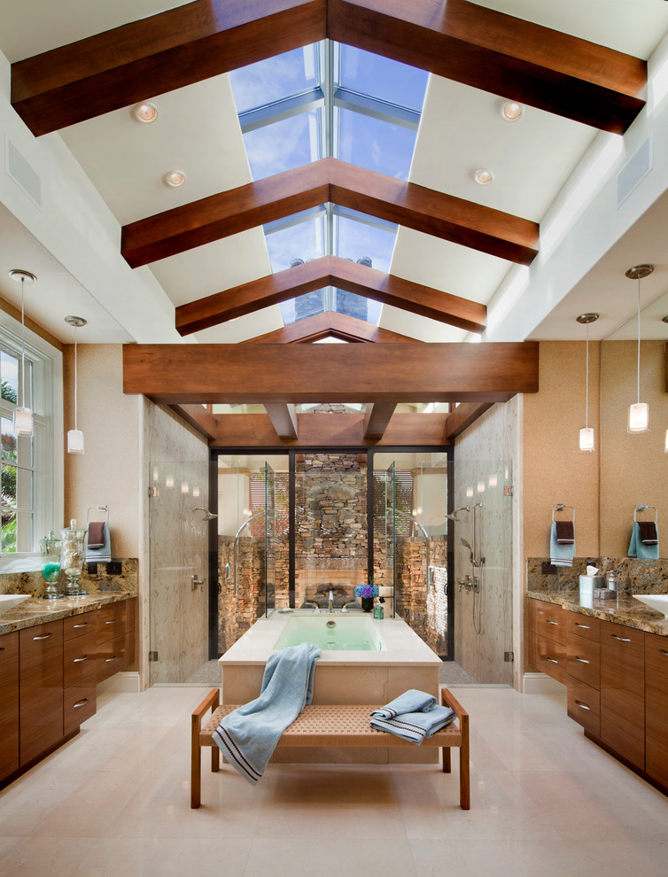 Cette image montre une salle de bain design en bois brun avec un lavabo encastré, un placard à porte plane, un plan de toilette en granite, une baignoire indépendante, une douche ouverte, WC à poser, un carrelage beige et un carrelage de pierre.