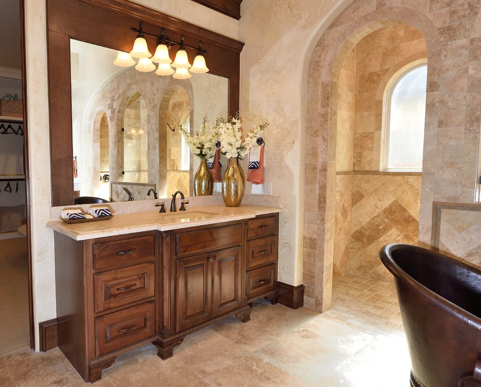 Inredning av ett medelhavsstil stort en-suite badrum, med luckor med infälld panel, skåp i mellenmörkt trä, ett fristående badkar, en dubbeldusch, beige kakel, keramikplattor, beige väggar, travertin golv, ett undermonterad handfat, marmorbänkskiva, beiget golv och med dusch som är öppen