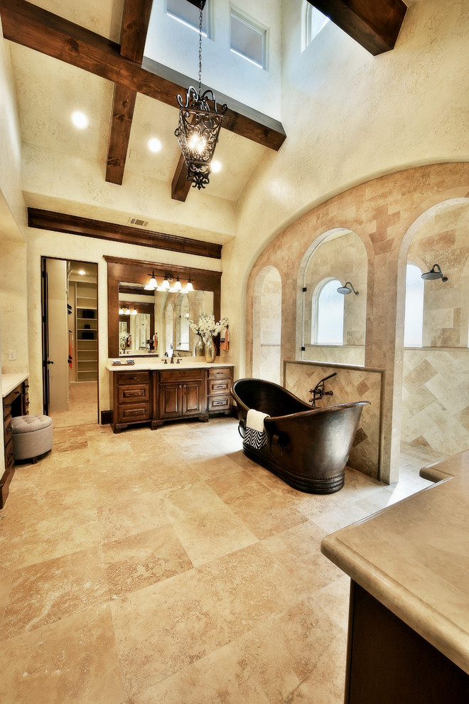 Bild på ett stort medelhavsstil en-suite badrum, med luckor med upphöjd panel, skåp i mellenmörkt trä, ett fristående badkar, en dubbeldusch, beige kakel, keramikplattor, beige väggar, travertin golv, ett undermonterad handfat, marmorbänkskiva, beiget golv och med dusch som är öppen