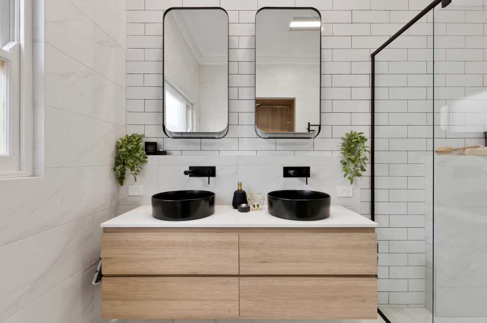 Exempel på ett mellanstort modernt vit vitt badrum med dusch, med släta luckor, skåp i ljust trä, en dusch i en alkov, vit kakel, tunnelbanekakel, ett fristående handfat, vitt golv och dusch med skjutdörr