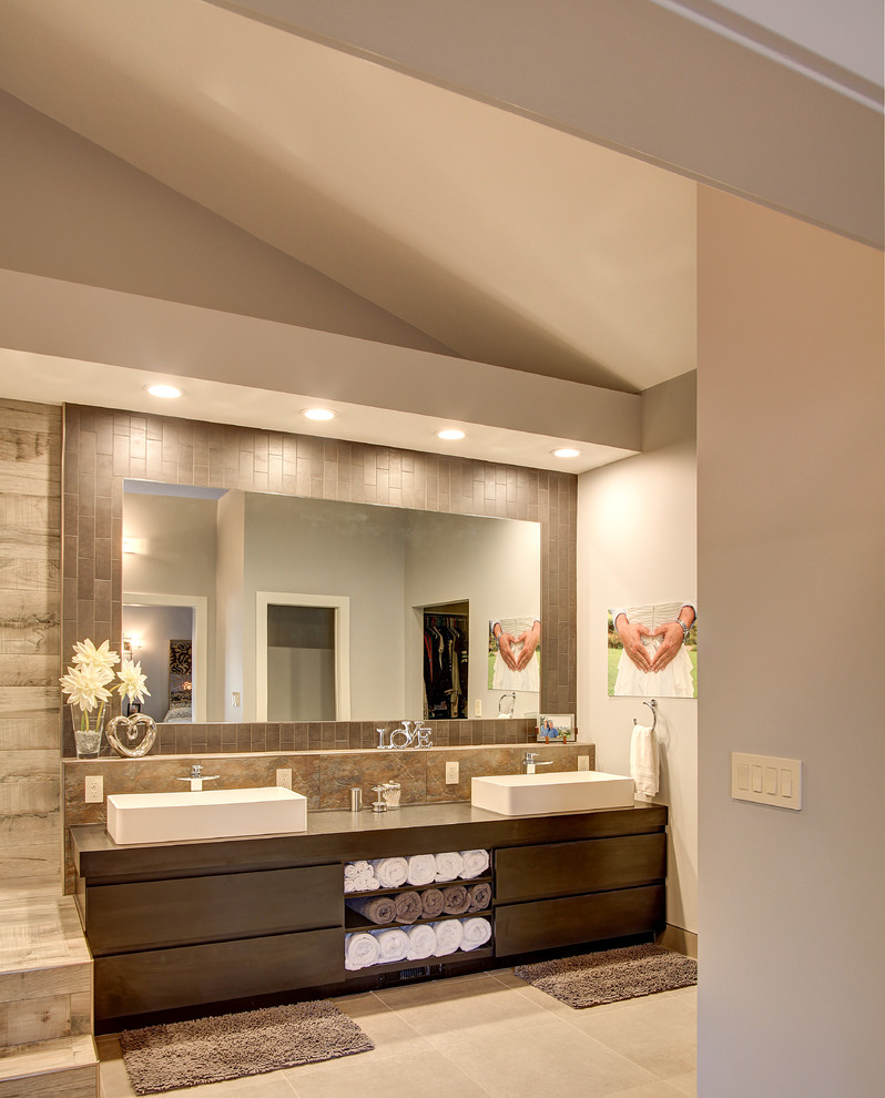 Aménagement d'une grande salle de bain moderne en bois foncé avec un placard à porte plane, un espace douche bain, WC séparés, un carrelage beige, un mur beige, un sol en carrelage de céramique, une vasque et un plan de toilette en bois.