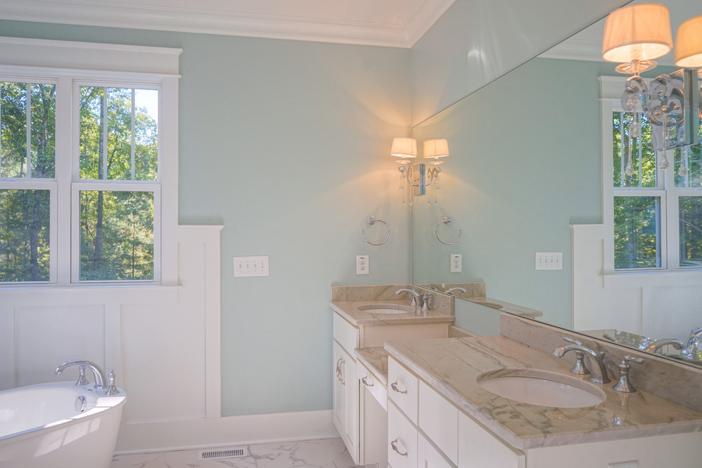 Inspiration for a mid-sized craftsman master marble floor and white floor bathroom remodel in Raleigh with shaker cabinets, white cabinets, a two-piece toilet, blue walls, an undermount sink, granite countertops and a hinged shower door