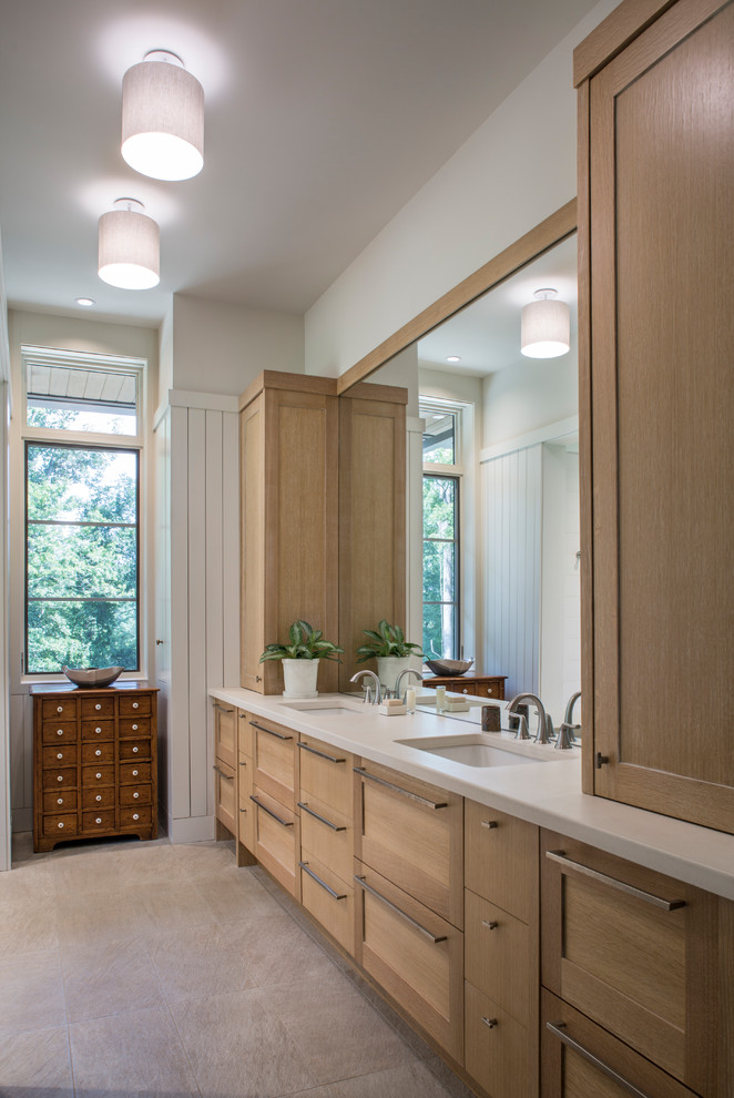 Cette photo montre une grande salle de bain chic en bois clair avec un placard à porte shaker, un mur blanc, un lavabo encastré, un sol gris et un plan de toilette blanc.