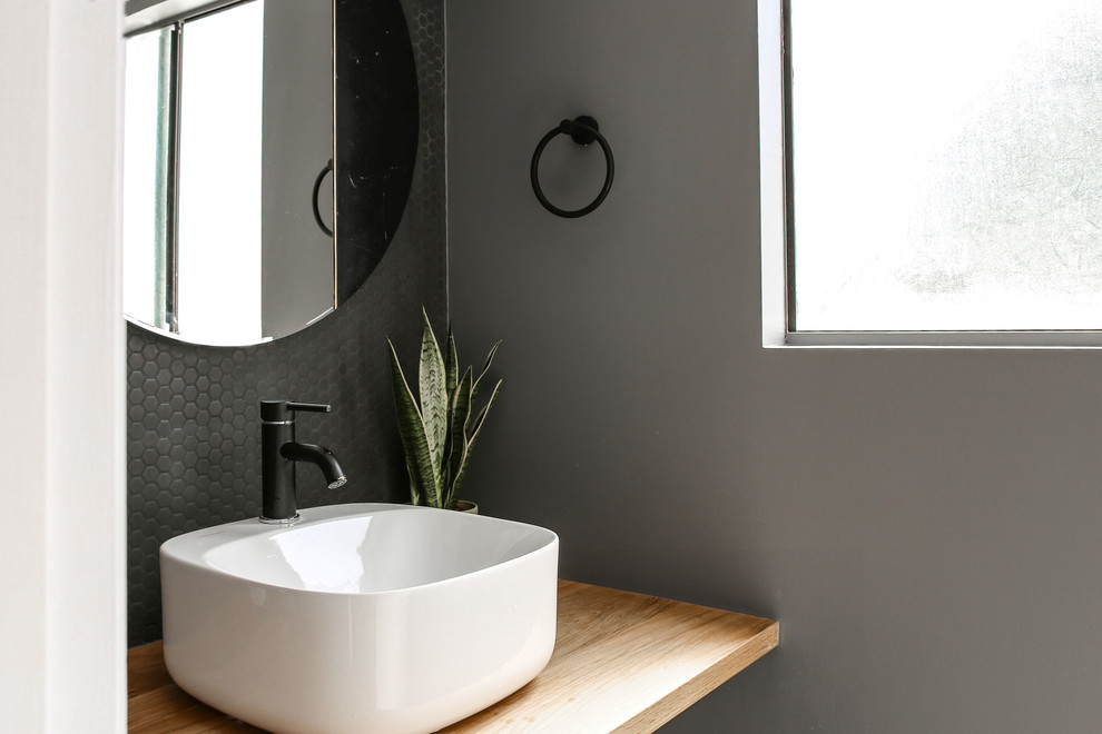 Exemple d'une petite salle de bain scandinave avec WC à poser, un carrelage gris, des carreaux de céramique, un sol en ardoise, un plan vasque et un sol gris.