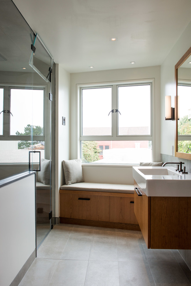 Inspiration för mellanstora moderna badrum med dusch, med ett väggmonterat handfat, släta luckor, skåp i mellenmörkt trä, en dusch i en alkov, beige kakel och vita väggar