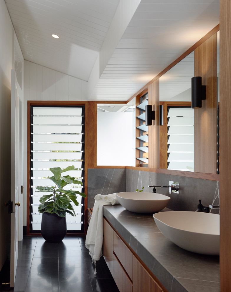 Aménagement d'une salle de bain principale contemporaine en bois brun avec un placard à porte plane, un mur blanc, une vasque, un sol noir, un plan de toilette gris, meuble double vasque, meuble-lavabo suspendu, un plafond en lambris de bois, un plafond voûté et du lambris de bois.