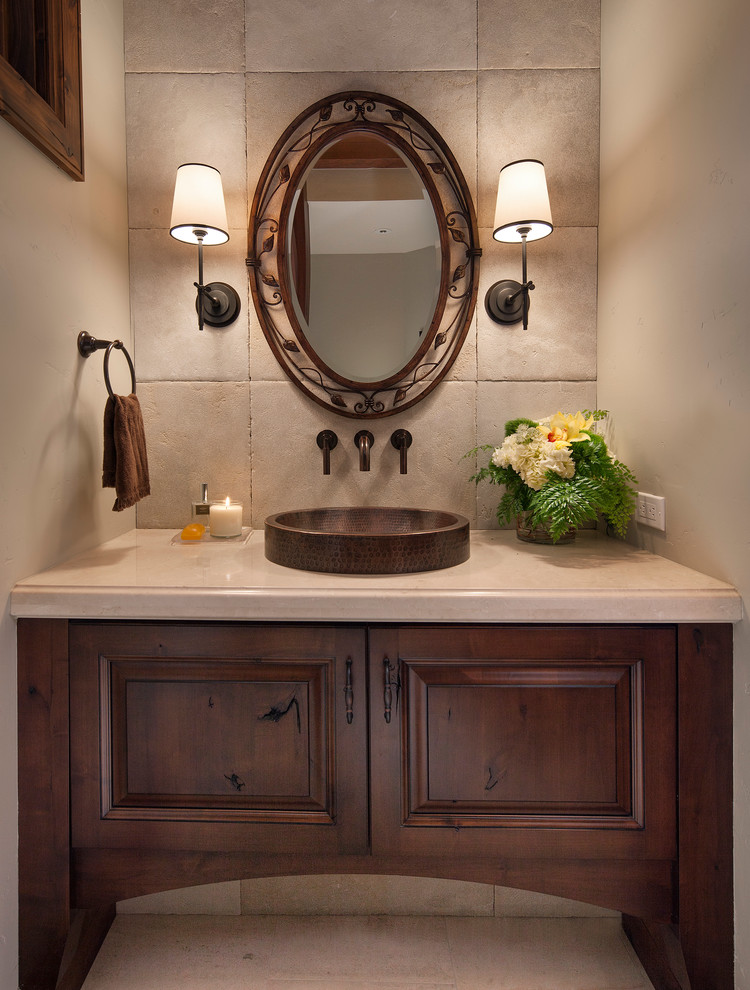 This is an example of a rustic bathroom in Denver with a vessel sink, raised-panel cabinets, dark wood cabinets, grey tiles, stone tiles and beige walls.
