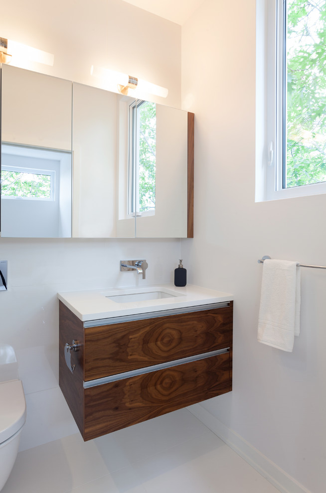 Réalisation d'une petite salle de bain principale minimaliste en bois brun avec un placard à porte plane et un plan de toilette en quartz modifié.