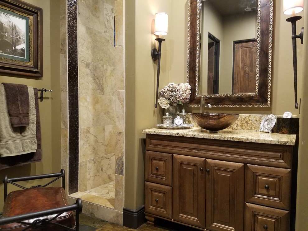 Example of a tuscan master glass tile slate floor double shower design in Sacramento with raised-panel cabinets, medium tone wood cabinets, a two-piece toilet, beige walls, a vessel sink and granite countertops