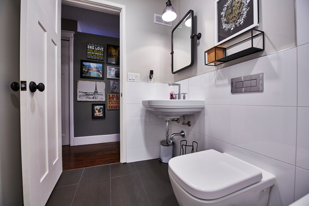 Cette image montre une salle d'eau bohème de taille moyenne avec WC suspendus, un carrelage blanc, des carreaux de porcelaine, un mur gris, un sol en carrelage de porcelaine, un lavabo suspendu et un sol marron.