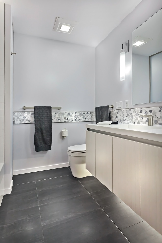 Inspiration for a mid-sized contemporary master multicolored tile and porcelain tile porcelain tile bathroom remodel in Minneapolis with a trough sink, flat-panel cabinets, light wood cabinets, solid surface countertops and white walls