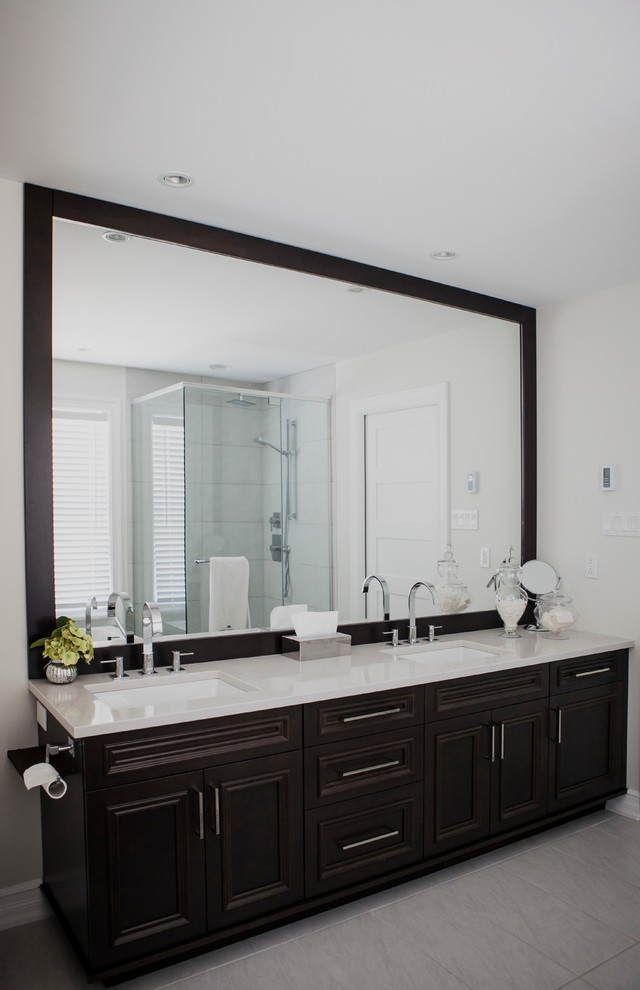 Photo of a traditional ensuite bathroom in Montreal with a submerged sink, shaker cabinets, dark wood cabinets, engineered stone worktops, a built-in bath, a corner shower, a two-piece toilet, grey tiles, porcelain tiles, white walls and porcelain flooring.