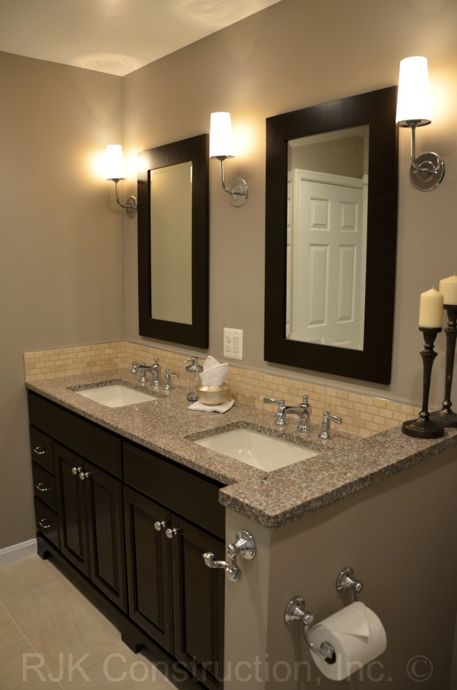 Inredning av ett modernt badrum, med ett undermonterad handfat, granitbänkskiva och beige väggar