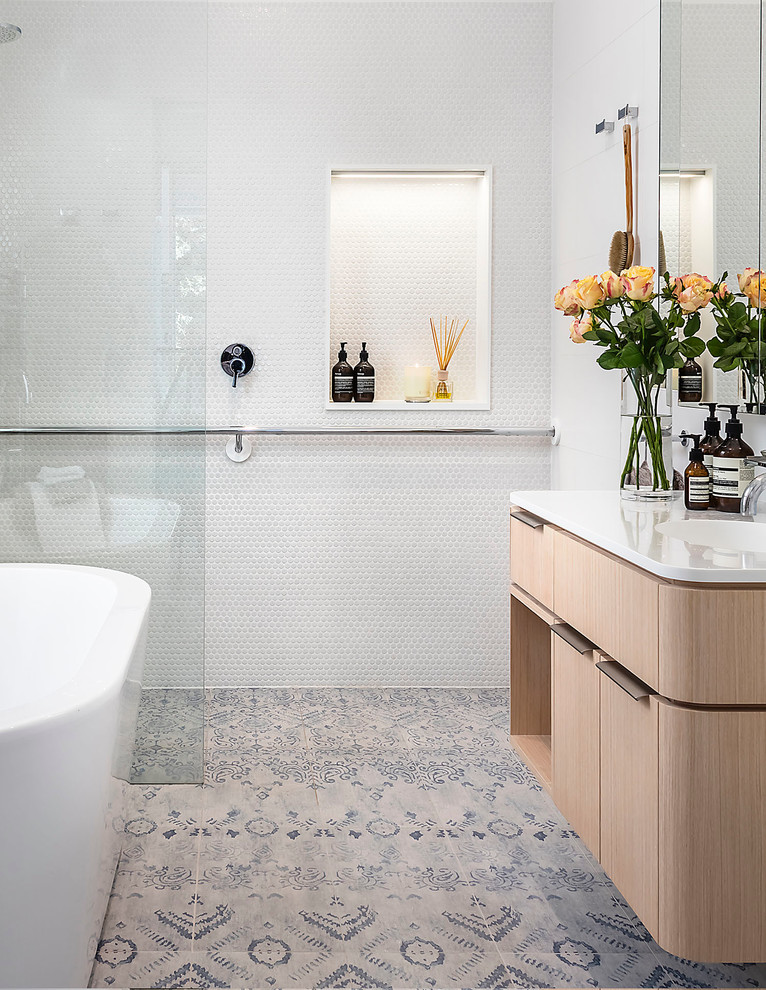 Photo of a contemporary ensuite bathroom in Melbourne with flat-panel cabinets, light wood cabinets, a freestanding bath, a built-in shower, white tiles, mosaic tiles, white walls, an integrated sink and an open shower.