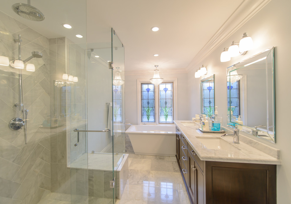 Design ideas for an expansive classic ensuite bathroom in Toronto with recessed-panel cabinets, dark wood cabinets, marble worktops, beige tiles, ceramic tiles, a freestanding bath, a double shower, a built-in sink, beige walls and marble flooring.
