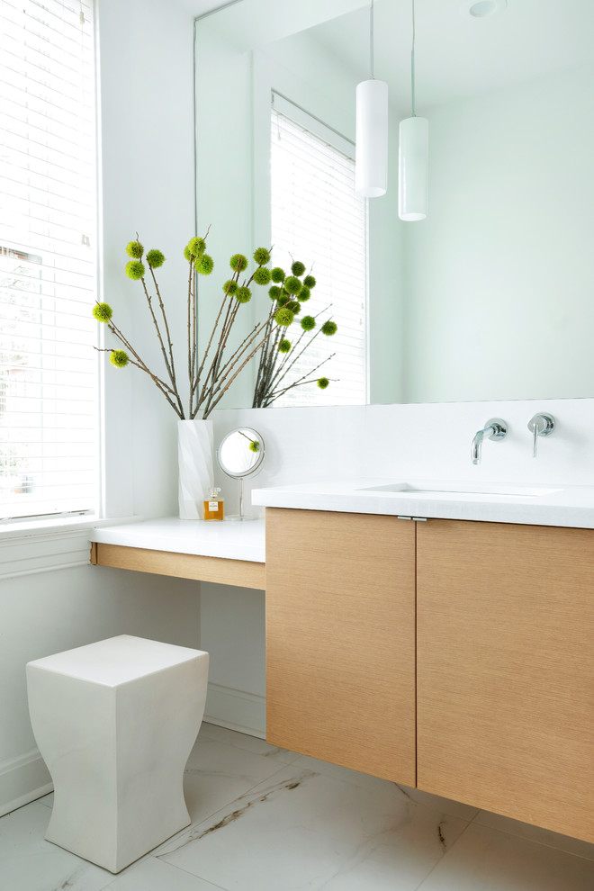 Modelo de cuarto de baño contemporáneo con armarios con paneles lisos, puertas de armario de madera clara, paredes blancas, lavabo bajoencimera, suelo blanco, encimeras blancas, suelo de mármol y ventanas