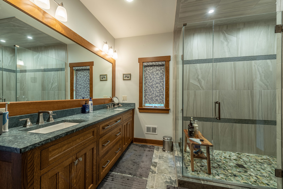 На фото: главная ванная комната среднего размера в стиле кантри с фасадами в стиле шейкер, коричневыми фасадами, душевой комнатой, раздельным унитазом, зеленой плиткой, керамической плиткой, бежевыми стенами, полом из керамической плитки, врезной раковиной, столешницей из гранита, серым полом, душем с распашными дверями и зеленой столешницей