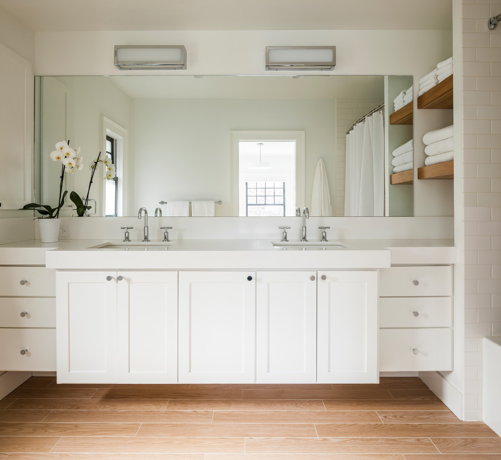 Foto på ett mellanstort vintage en-suite badrum, med skåp i shakerstil, vita skåp, vita väggar, ljust trägolv, ett undermonterad handfat, beiget golv, ett badkar i en alkov, vit kakel och keramikplattor