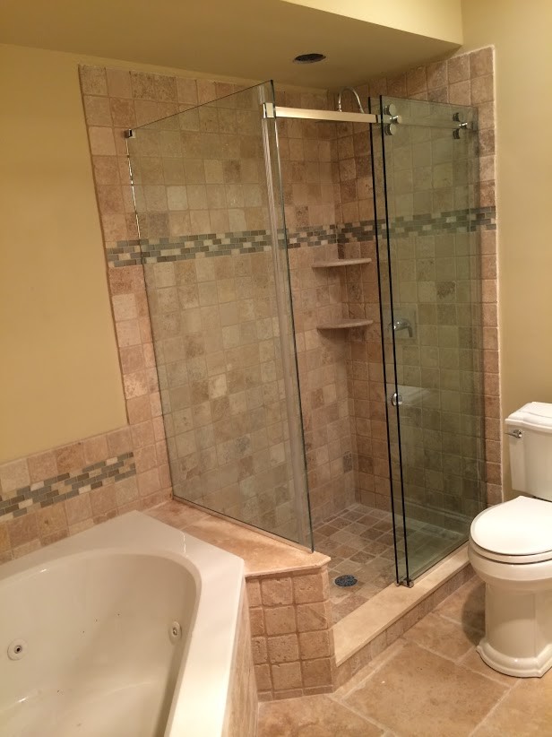 Immagine di una stanza da bagno di medie dimensioni con vasca idromassaggio, doccia ad angolo, WC a due pezzi, piastrelle beige, piastrelle marroni, piastrelle in ceramica, pareti beige e pavimento in pietra calcarea