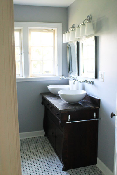Inspiration för moderna badrum, med ett fristående handfat, skåp i mörkt trä, marmorbänkskiva, en dusch/badkar-kombination och vit kakel