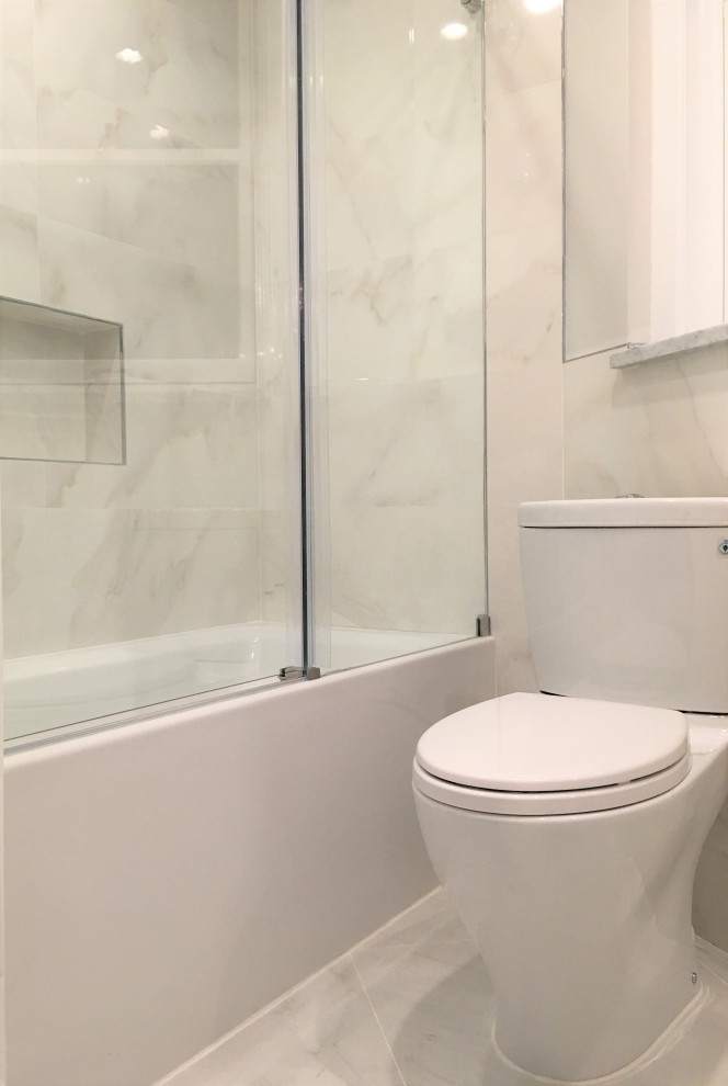 Источник вдохновения для домашнего уюта: маленькая ванная комната в стиле неоклассика (современная классика) с белыми фасадами, ванной в нише, душем над ванной, раздельным унитазом, белой плиткой, керамогранитной плиткой, белыми стенами, полом из керамогранита, монолитной раковиной, столешницей из искусственного кварца, белым полом, душем с раздвижными дверями, белой столешницей, тумбой под одну раковину и напольной тумбой для на участке и в саду