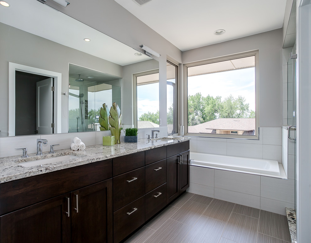 Cette image montre une grande salle de bain principale design en bois foncé avec un placard à porte plane, une baignoire posée, une douche d'angle, un carrelage blanc, un carrelage de pierre, un mur gris, un sol en ardoise, un lavabo encastré et un plan de toilette en granite.