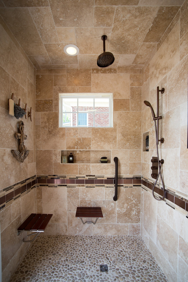 Klassisches Badezimmer mit offener Dusche, beigen Fliesen, beiger Wandfarbe, Kiesel-Bodenfliesen und Steinwänden in Sonstige